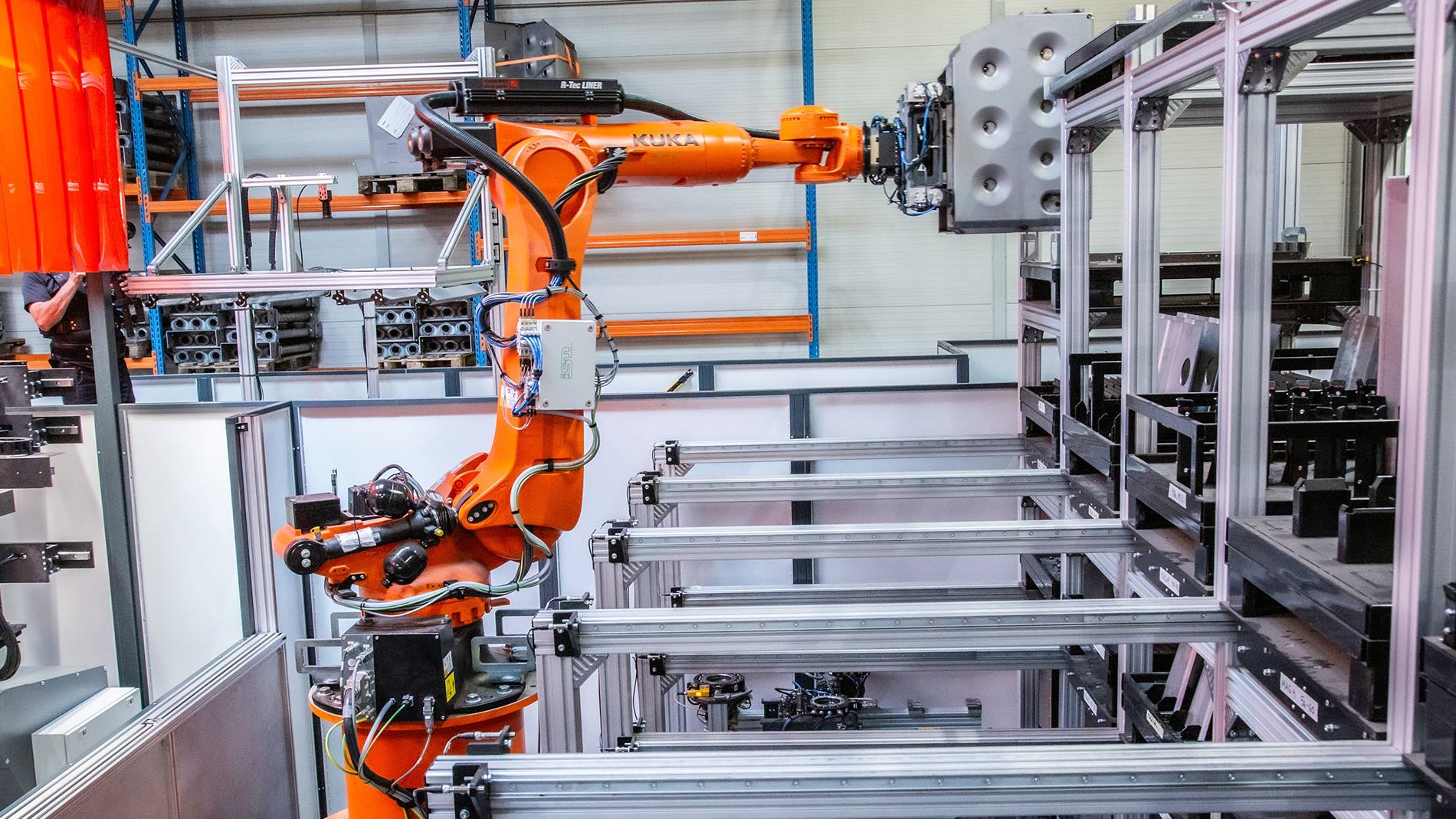 Ein KUKA Handlingroboter entnimmt die in der Heftzelle ben?tigten Bauteile aus dem Regalsystem.