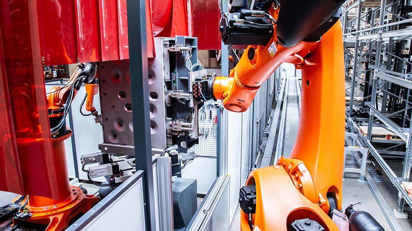 Der KUKA Handlingroboter positioniert den zu schwei?enden Kessel exakt in der bereits eingespannten Vorrichtung.