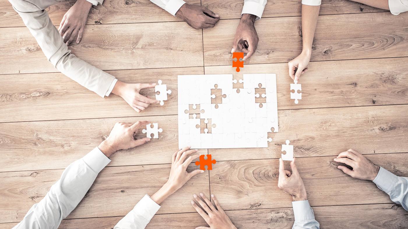 Human working together on a puzzle stands for the way of working at KUKA
