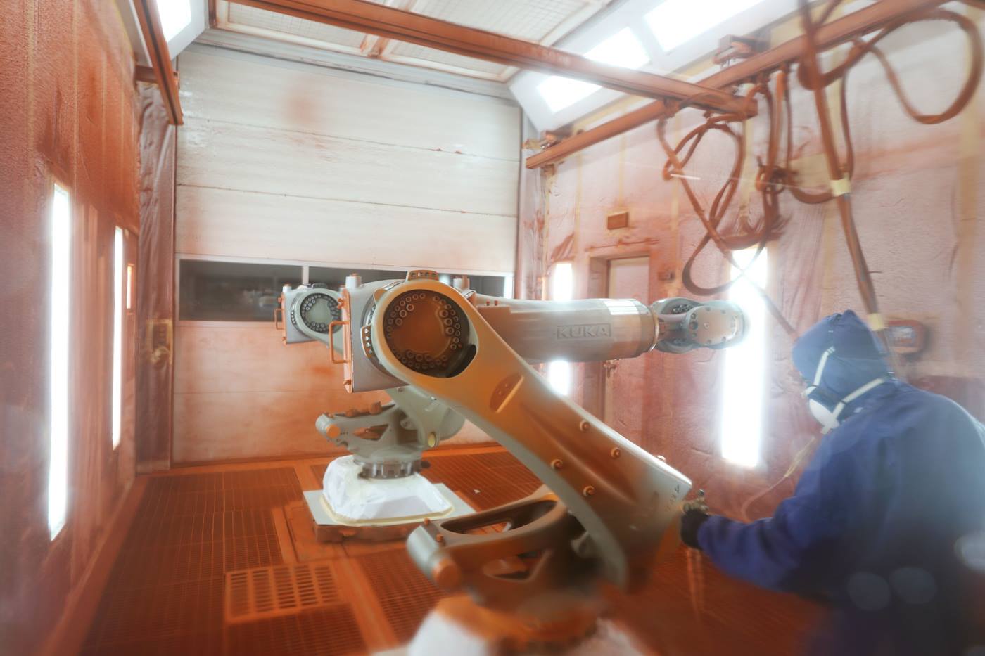 Mann lackiert Roboter