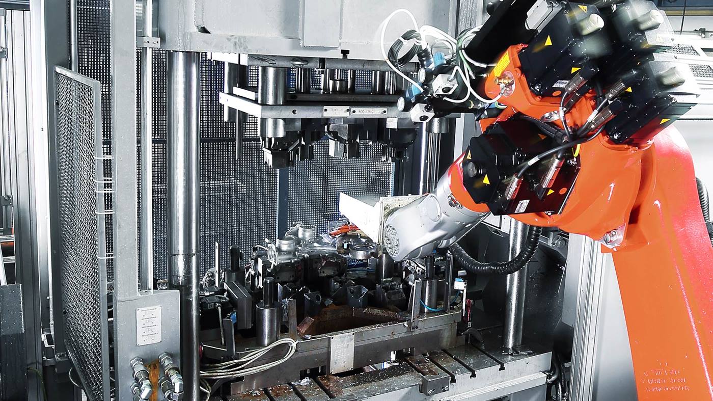 Der Roboter legt das Gu?teil zum Trennnen und Entgraten in die Presse