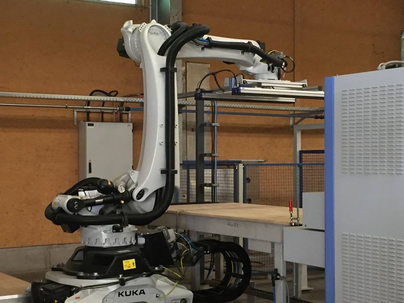 KUKA Stapelroboter des Typs KR QUANTEC entimmt Holzplatten aus Plattenpresse