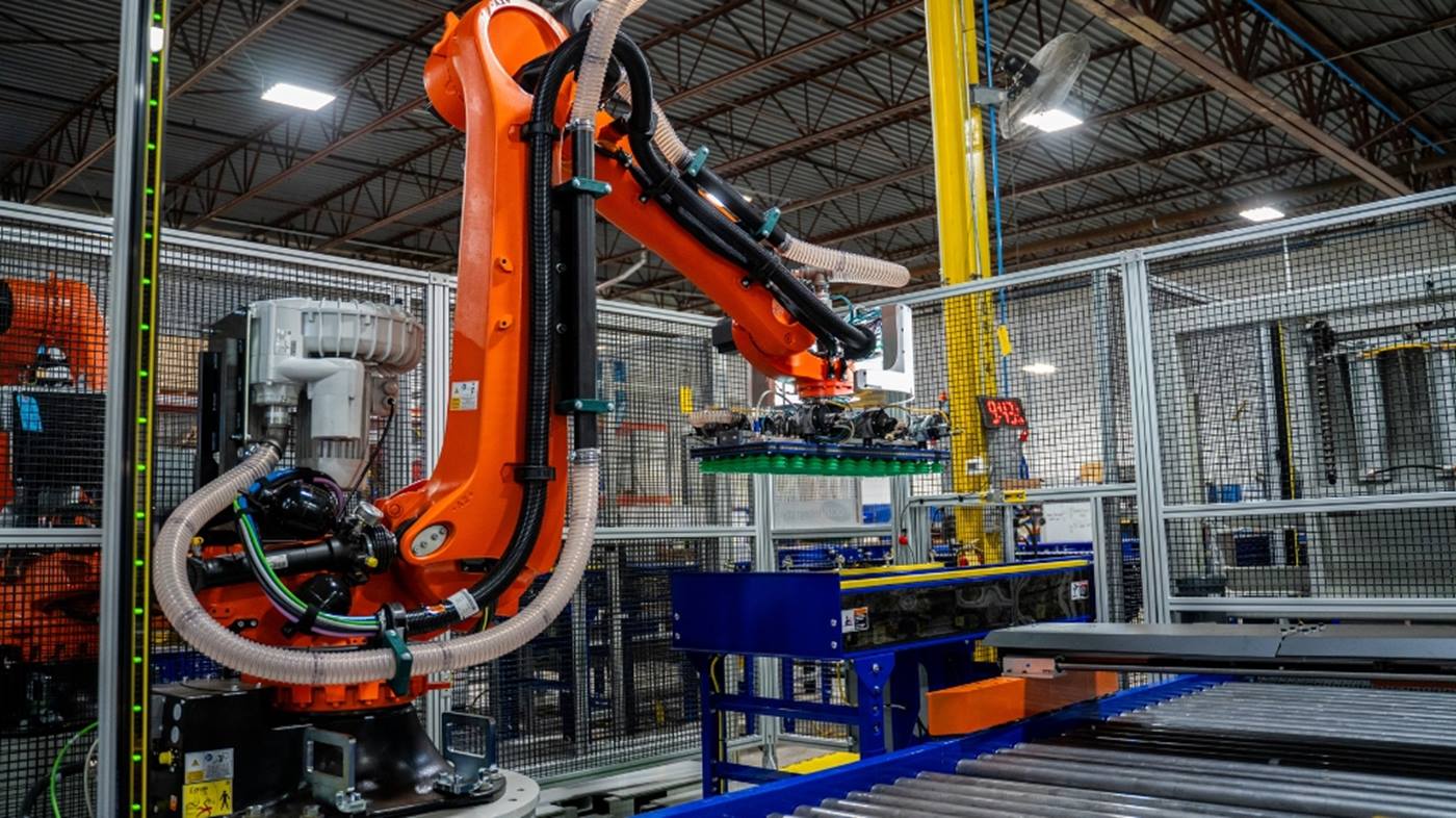 KR QUANTEC PA palletizes items from a conveyer line. 