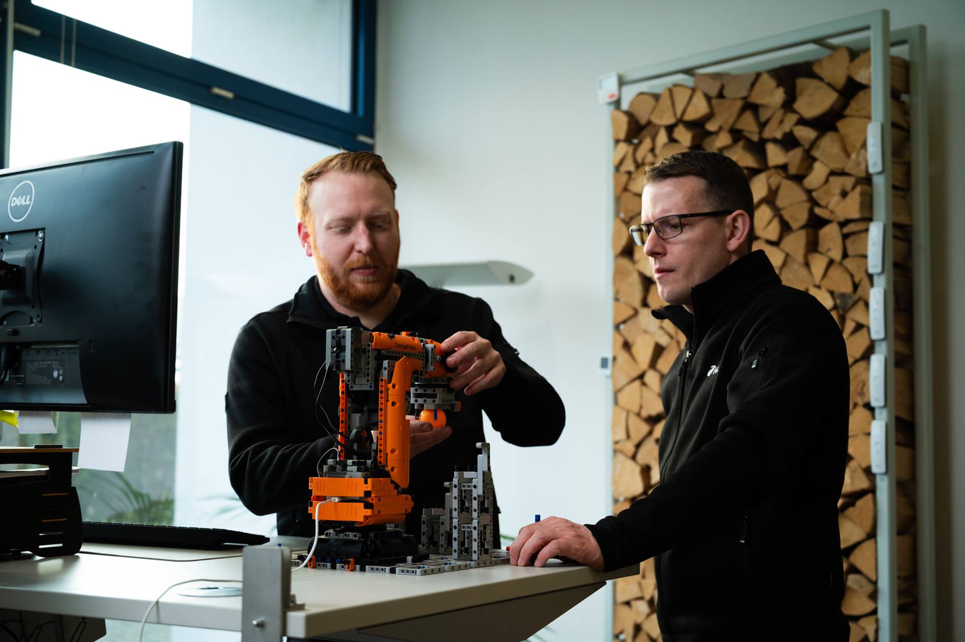Martin Altmeier, HASE Kaminofenbau GmbH, und ein weiterer HASE-Mitarbeiter an einem Roboter von KUKA im Gespr?ch.