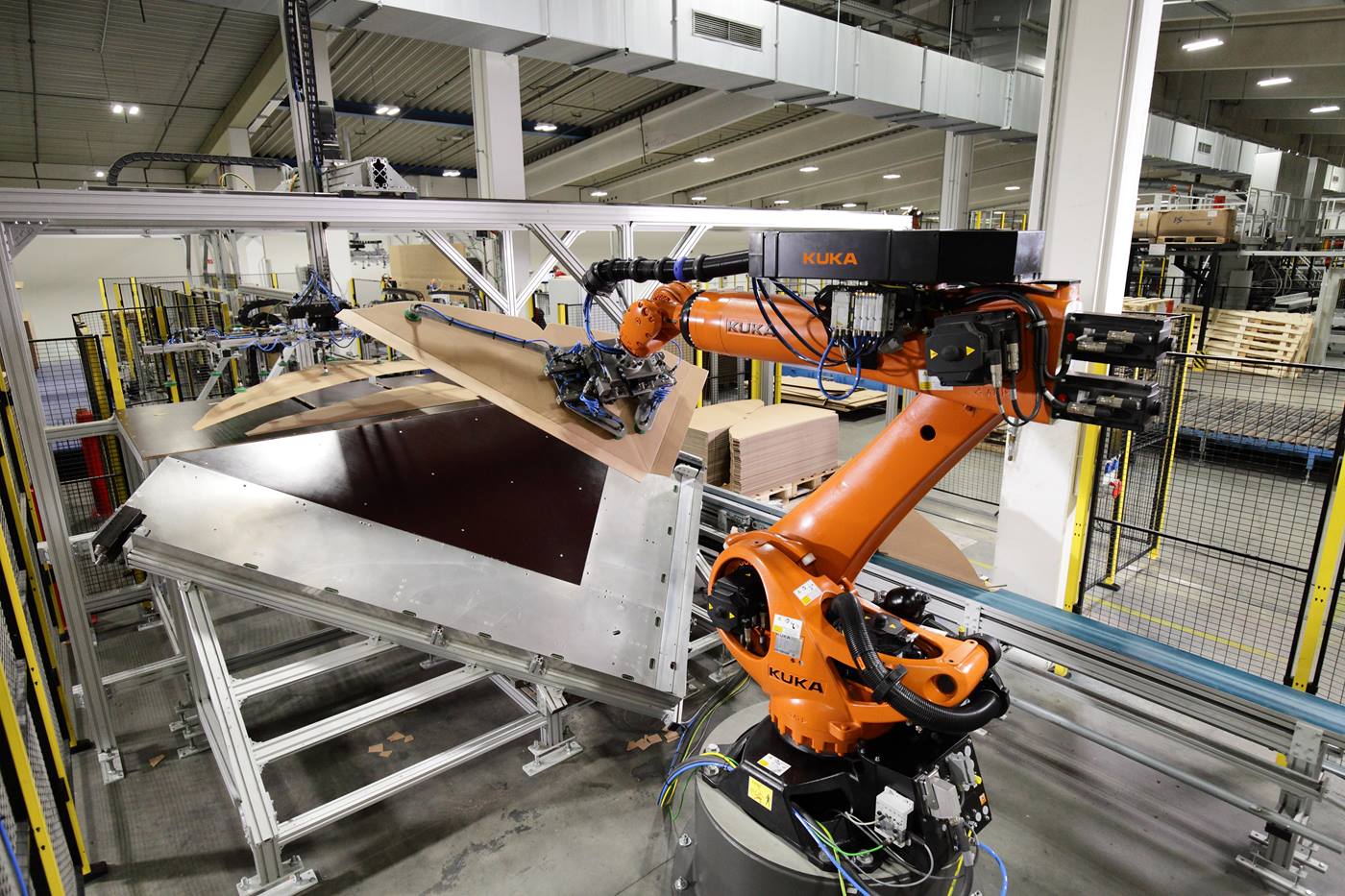 KUKA Verpackungsroboter nimmt Wellpappbogen mit Greifer auf.