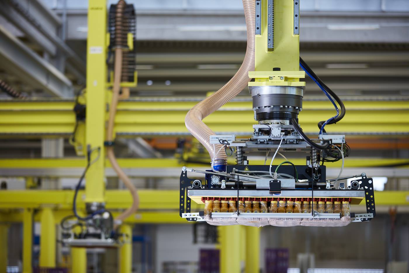 KUKA Roboter mit Sauggreifern positioniert eine Lage mit Fruchts?ften
