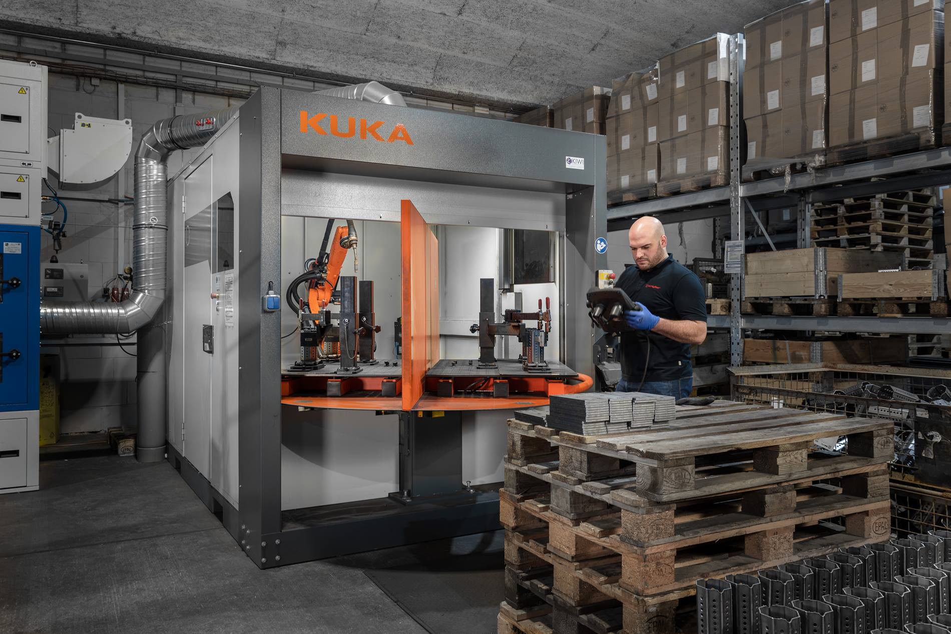 Mann steht vor KUKA Schwei?roboterzelle 